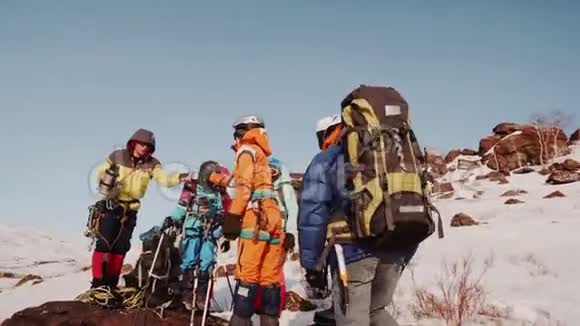 登山者经过正在休息一位游客从一个热水瓶里递给女孩茶视频的预览图