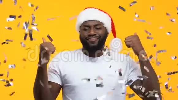 非洲裔美国人戴着圣诞帽在坠落的纸屑下跳舞狂欢派对视频的预览图