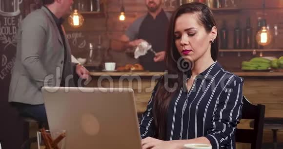 一个漂亮女人从右到左的幻灯片镜头集中在她的电脑上打字视频的预览图