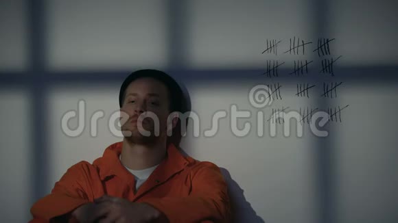 男囚犯看着牢房墙上的交叉线长期监禁视频的预览图