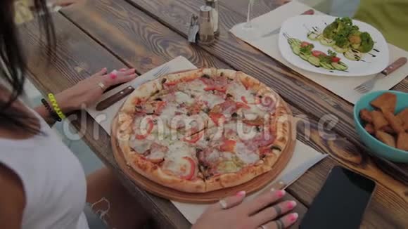 桌上放着新鲜披萨一个女人正准备吃视频的预览图