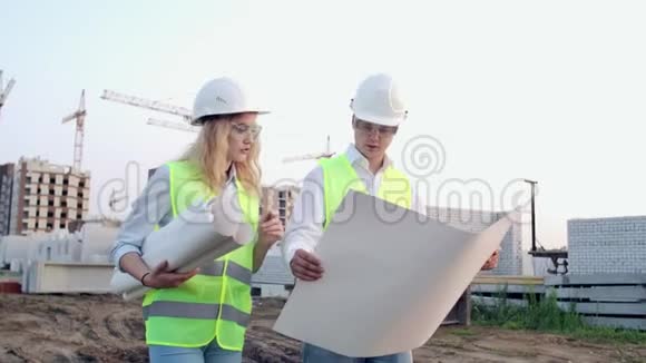 施工现场有图纸的工人两名工人一名男子一名妇女在保护性的哈达工作在视频的预览图