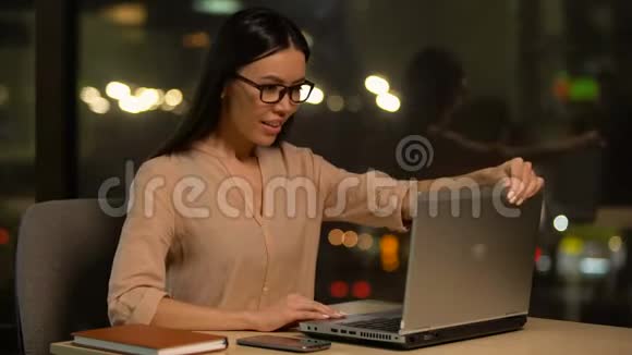 女孩从笔记本电脑上读到好消息显示出是的手势成功的项目视频的预览图