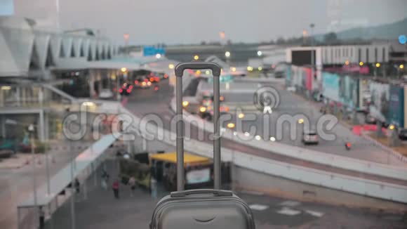 带可伸缩手柄的手提箱机场的行李包靠在模糊的窗户上4k视频的预览图