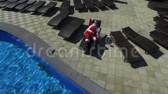 空中观景圣诞老人戴着太阳镜在躺椅上闲逛视频的预览图
