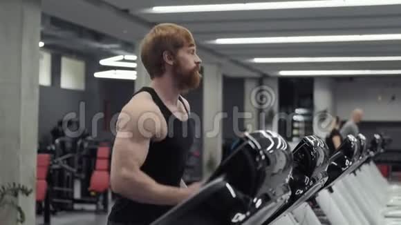 年轻的红发运动员在运动健身房里锻炼和跑步视频的预览图