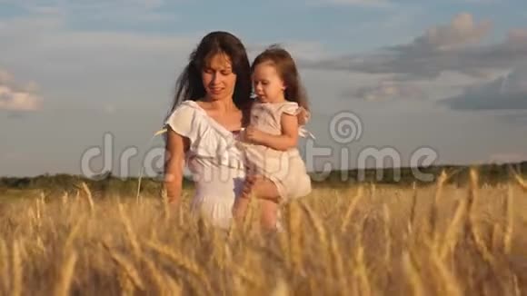 小女儿在麦田里吻妈妈幸福的家庭旅行孩子在妈妈怀里妈妈带着孩子走视频的预览图