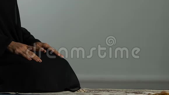 穆斯林女性坐在祈祷地毯上默默地与真主交谈宗教视频的预览图