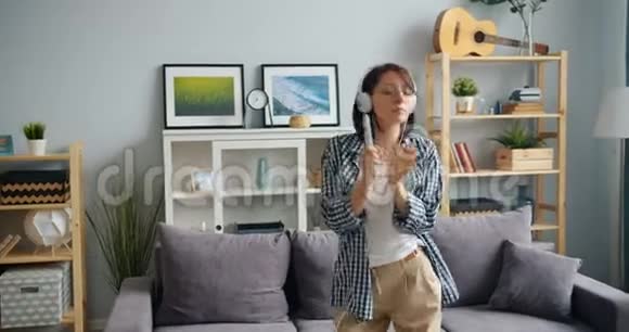 听音乐的女孩用遥控唱歌用耳机跳舞视频的预览图