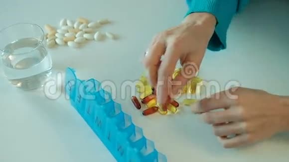 女人在一周内在蓝色的药片盒里分类营养维生素视频的预览图
