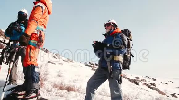 一群登山者站着用热水瓶喝茶他们聊天放松准备爬山视频的预览图
