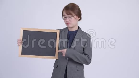 年轻严肃的亚洲女商人拿着黑板竖起大拇指视频的预览图