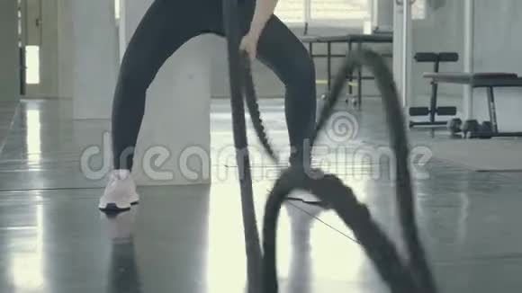 年轻的亚洲女人在健身房做战绳锻炼亚洲女孩在健身与教练视频的预览图