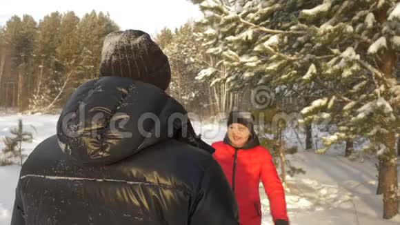 微笑的女人拥抱和亲吻男人而冬天在雪地公园开会视频的预览图