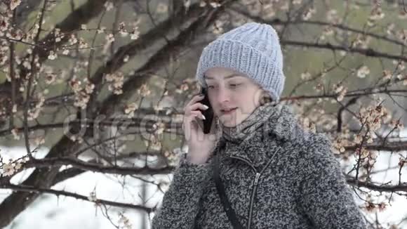 戴帽子的女孩在打电话春天雪橇视频的预览图
