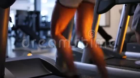 漂亮的晒黑的女性腿在健身房的跑步机上跑步后景视频的预览图