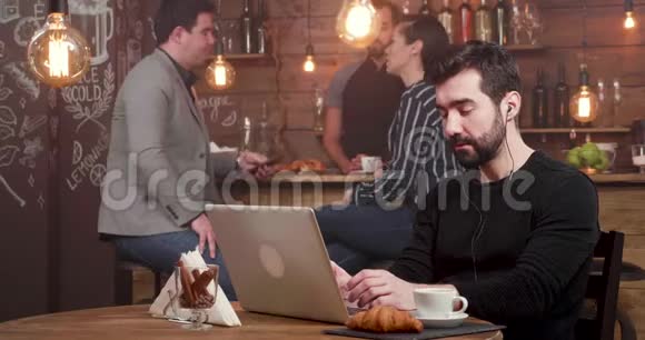 年轻人在咖啡店里做自由职业者时为自己的成就欢呼视频的预览图