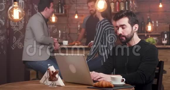 一个长胡子的帅哥在繁忙的咖啡店工作非常热情视频的预览图