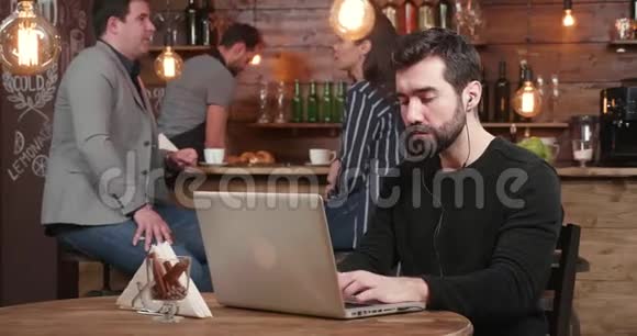 年轻的自由职业者在他的笔记本电脑上工作早餐供应咖啡和羊角面包视频的预览图