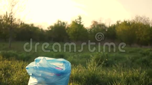 活跃的女人打扫公园里的杂物把它折叠在一个蓝色的塑料袋里把包裹拿在手里然后出去视频的预览图