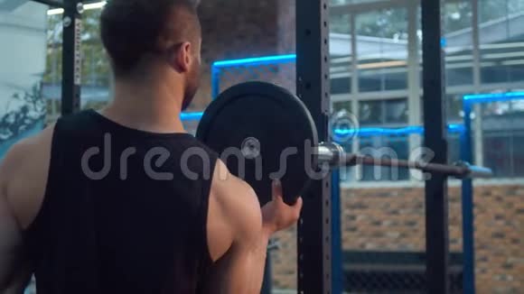 健美运动员在杠铃上放重物视频的预览图