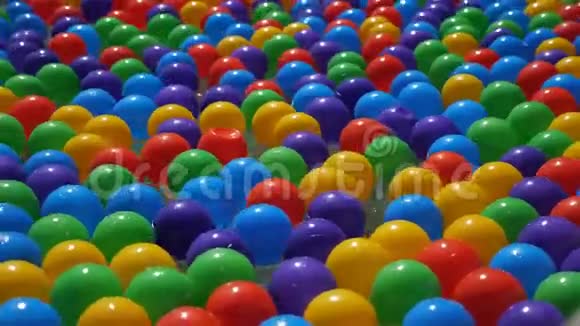 五颜六色的小塑料球在水中漂浮和移动特写视频的预览图