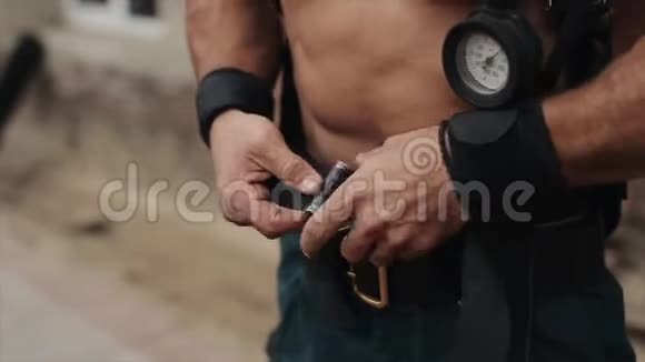 一位帅气的赤膊青年用压力表系设备皮带近景视频的预览图