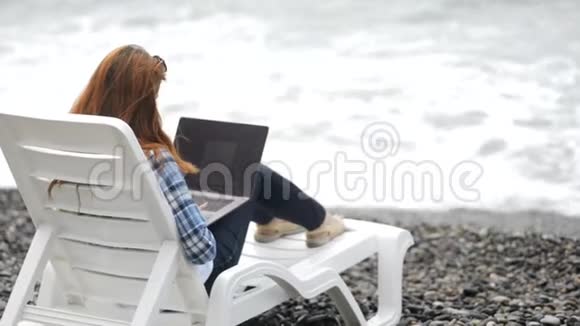 忙碌的女士在海边的笔记本电脑上写电子邮件视频的预览图