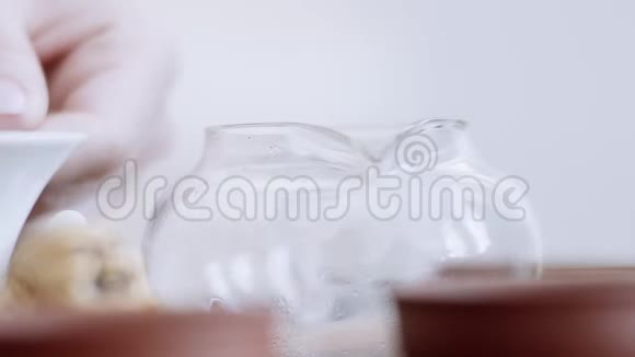 特写镜头女孩手轻轻地把筛子放在水壶上把香茶倒进茶壶里视频的预览图