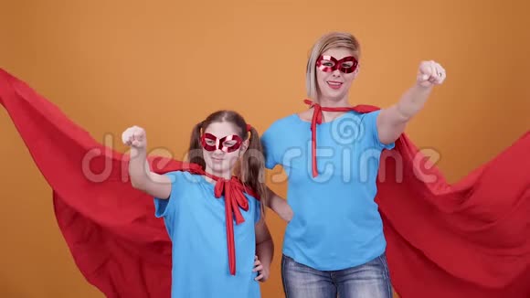 年轻的女人和一个女孩在看镜头时假装是超级英雄视频的预览图