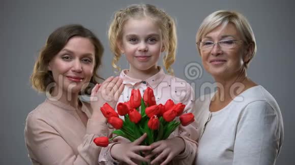 美丽的奶奶和母亲手里拿着郁金香拥抱着女儿视频的预览图