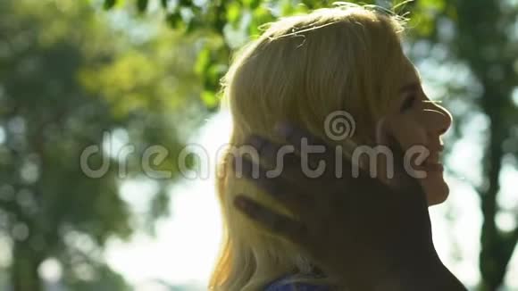 非裔美国男人温柔地亲吻和拥抱他的金发女人视频的预览图