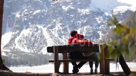 年轻夫妇在旅行坐在长凳上欣赏风景视频的预览图