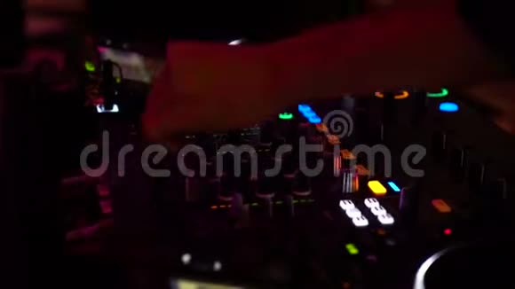夜总会闪光灯下dj手在混音器上混音的剪接镜头视频的预览图
