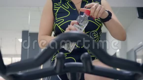 女人在自行车锻炼时喝水视频的预览图