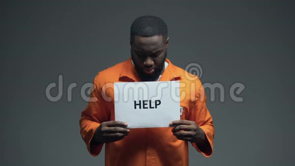 非洲裔美国男性囚犯手持帮助标志要求正义虐待视频的预览图