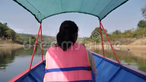 女游客坐在船上观赏河流和自然森林的风景视频的预览图