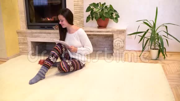 女孩拿着平板电脑坐在地上视频的预览图