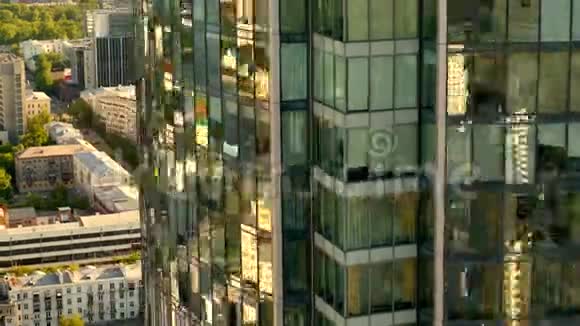在温暖的阳光明媚的日子里夏天可以俯瞰俄罗斯大城市建筑物树木和现代玻璃摩天大楼股票视频的预览图