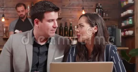 一位男性和女性商业伙伴讨论笔记本电脑屏幕上的内容的特写镜头视频的预览图