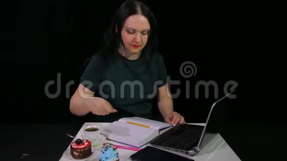 咖啡屋里的一个女人喝着黑背景的白色杯子里的咖啡在看日记时写日记视频的预览图