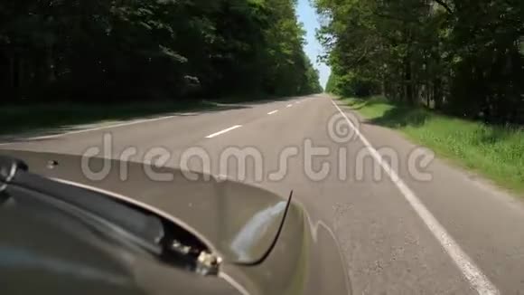 汽车沿着绿色森林的道路行驶你可以看到引擎盖4K慢慢视频的预览图