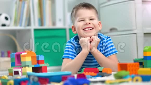 学龄前男孩正在幼儿园里玩不同颜色的玩具砖视频的预览图