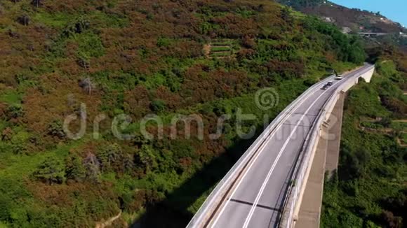 海边山上公路桥的鸟瞰图周围有草地森林和山脉在无人机上飞行Riomaggio视频的预览图