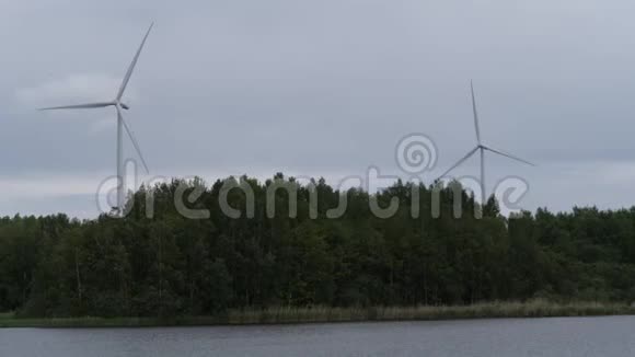 湖边的森林里矗立着巨大的风车新技术4K慢Mo视频的预览图