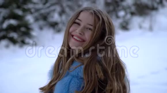 年轻美丽的女孩独自在冬天的森林里她在看摄像机女孩微笑着调情她高兴视频的预览图