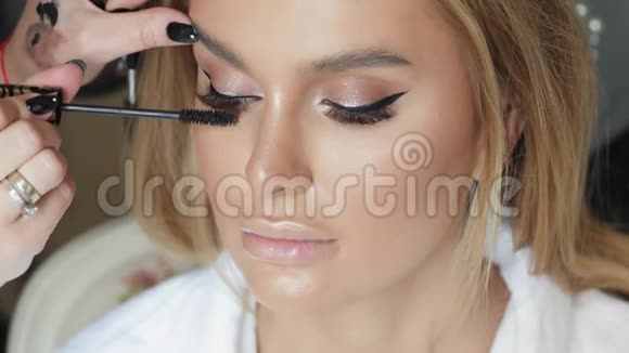 化妆师用一个年轻女人做化妆睫毛视频的预览图