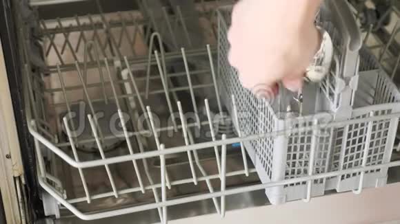 男人把脏盘子和餐具放进洗碗机里视频的预览图
