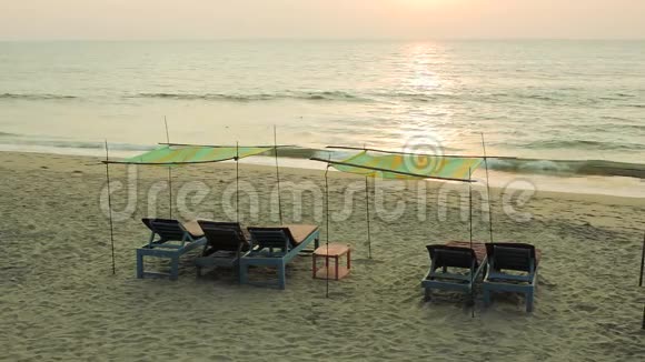 空蓝的木沙滩在沙滩上的檐篷下在大海的背景下大海的海浪和太阳的小路上视频的预览图