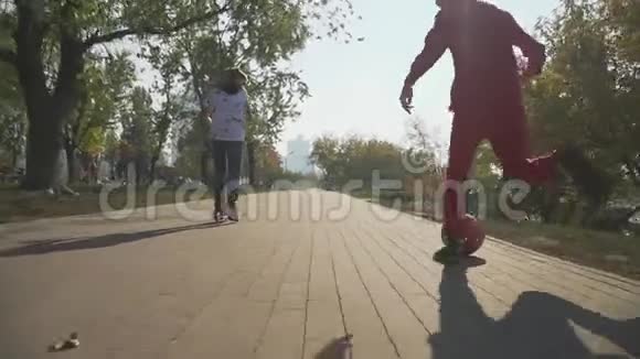 这个男孩正在骑滑板车孩子正跑在公园里踢红球视频的预览图